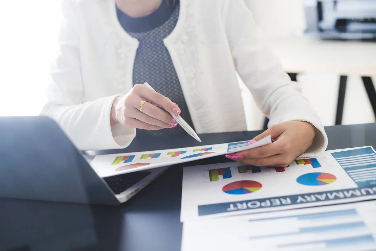 Professional reviewing MHRA compliance data on paper and laptop